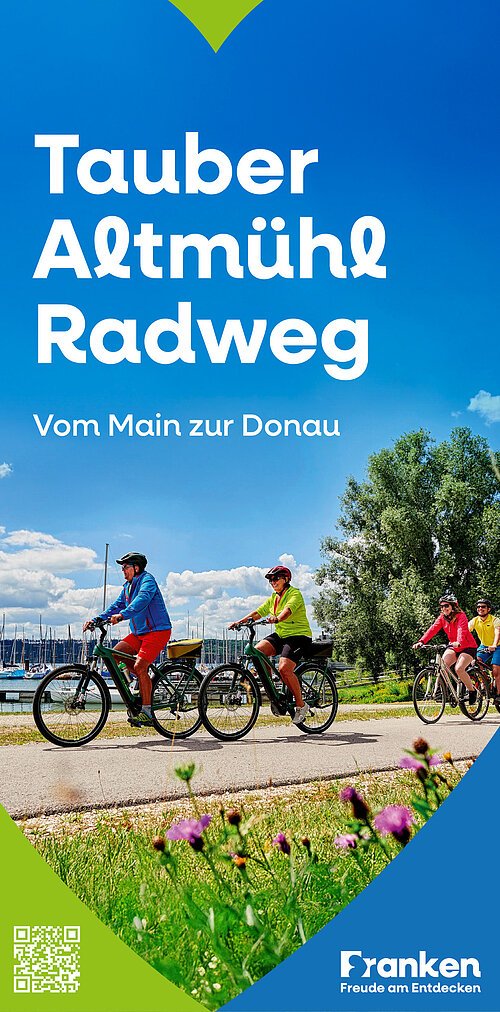 Vier Radfahrer auf einem Weg am Wasser mit Booten und Bäumen, Text Tauber Altmühl Radweg vom Main zur Donau